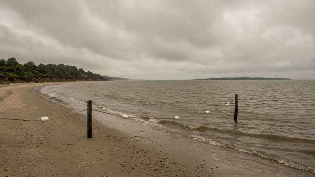Empty shoreline with cloudy water after a swim advisory