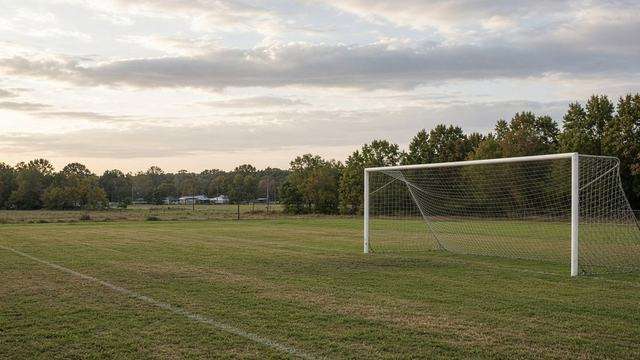 High school soccer match under afternoon lights