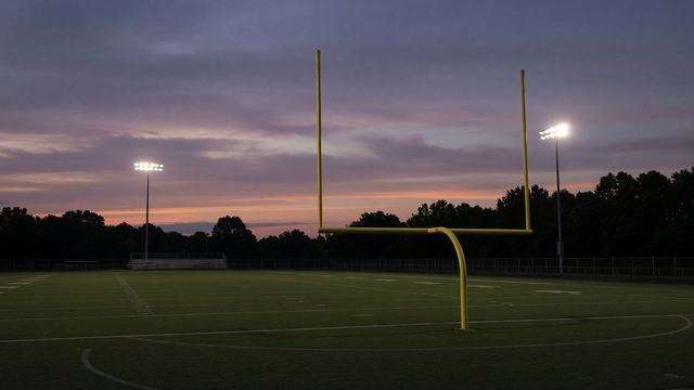 High school football field under Friday night lights